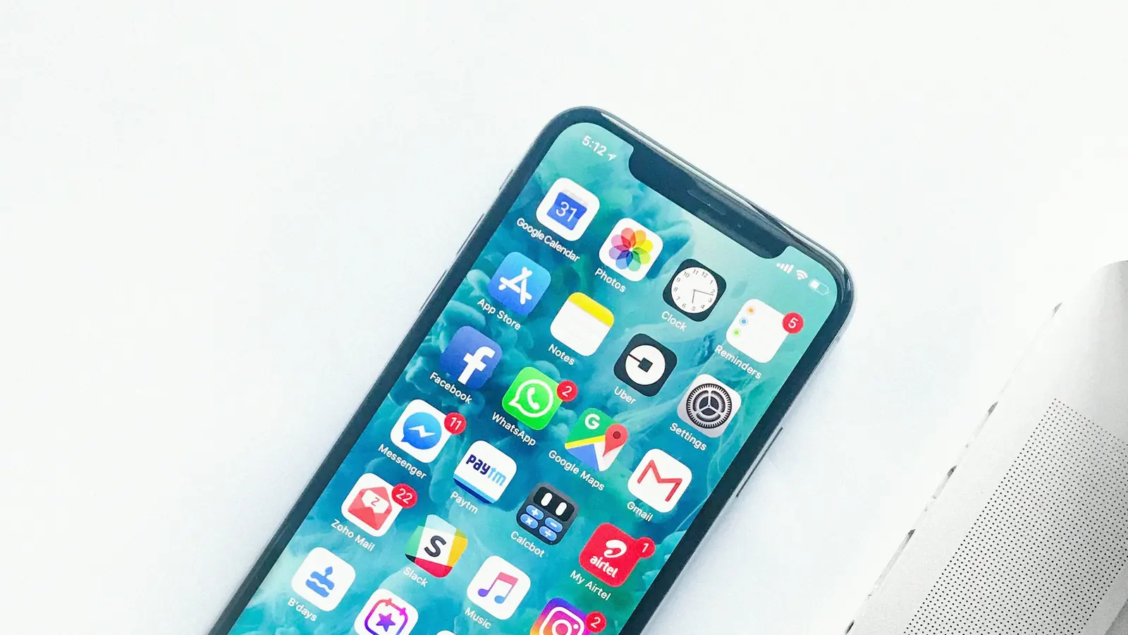 Smartphone showing a colorful app beside a laptop