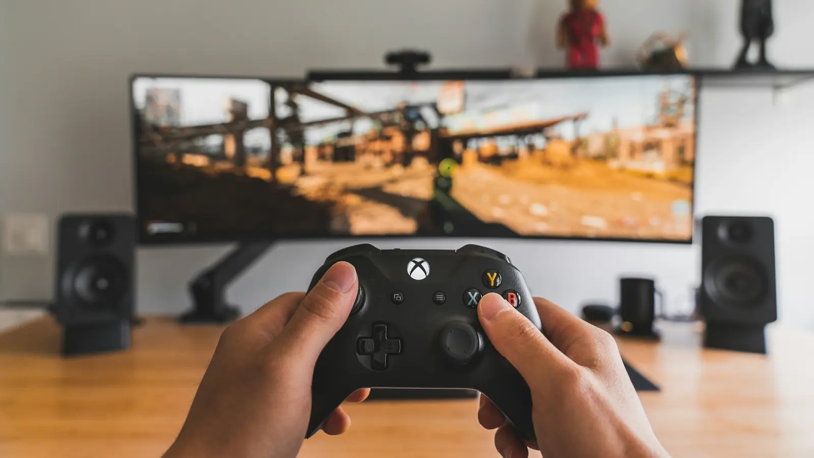 Player holding a black game controller in front of a screen